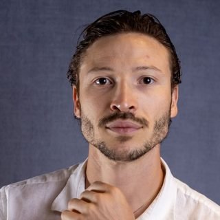 Gabriel Honrar, de camisa branca, olhando pra câmera